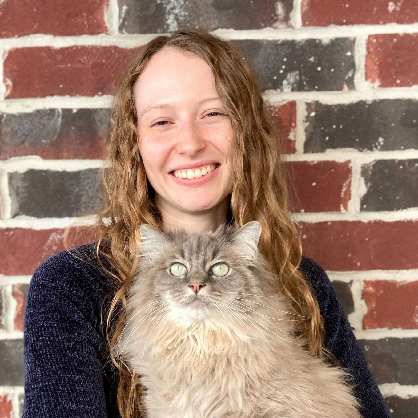 Dr. Kat Sutherland with a cat.  Image links to Kat's bio.